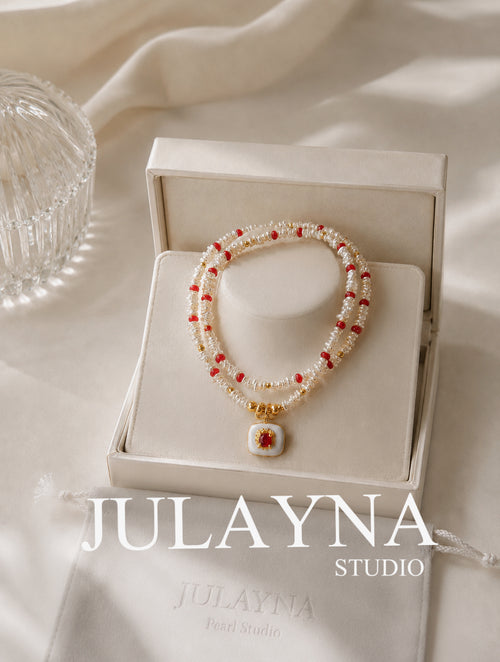 Keshi pearl necklace with red ruby accents and gold pendant, shown in gift box