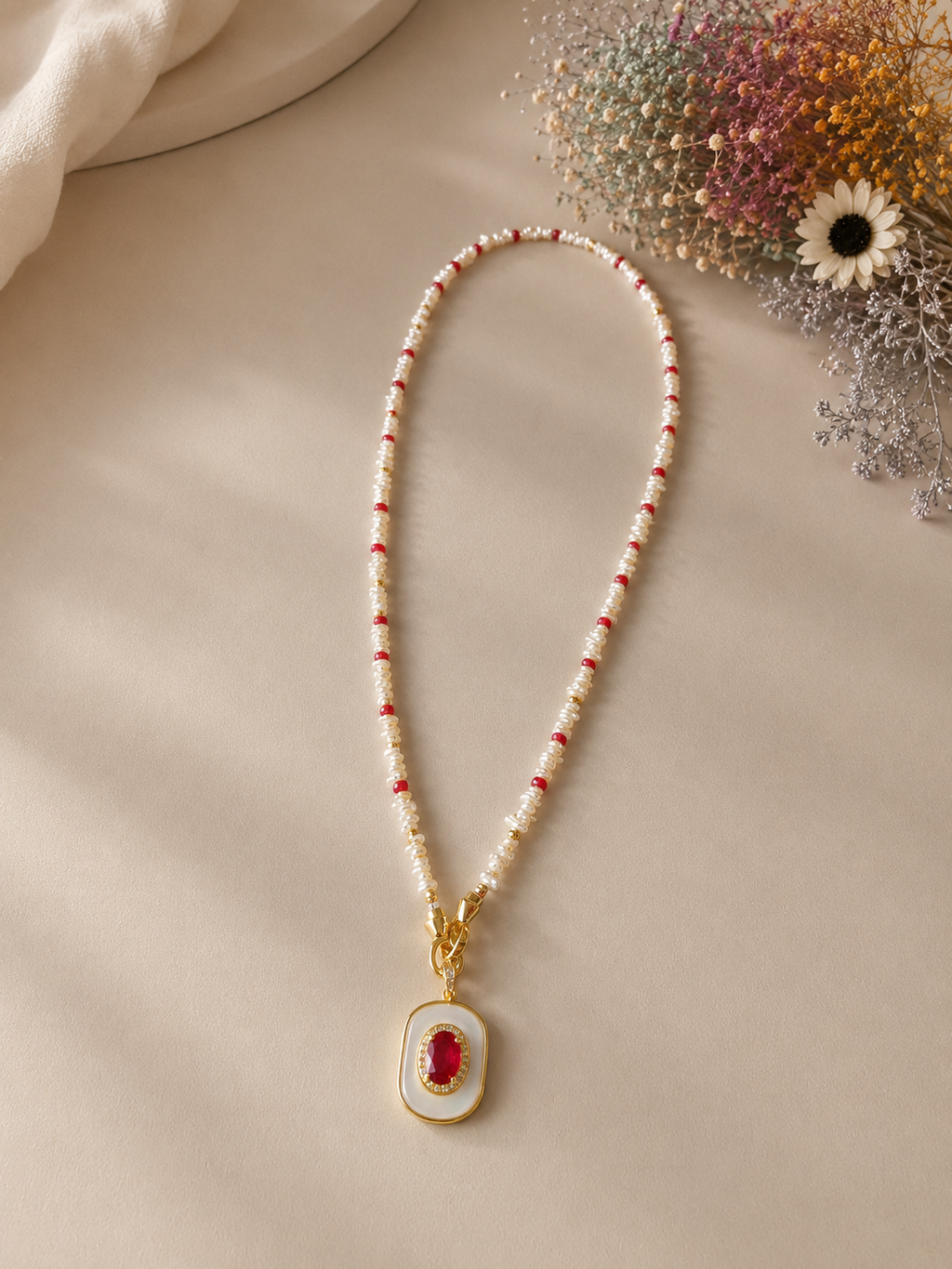 Beaded ruby pendant necklace with gold-tone bail and mother-of-pearl oval drop