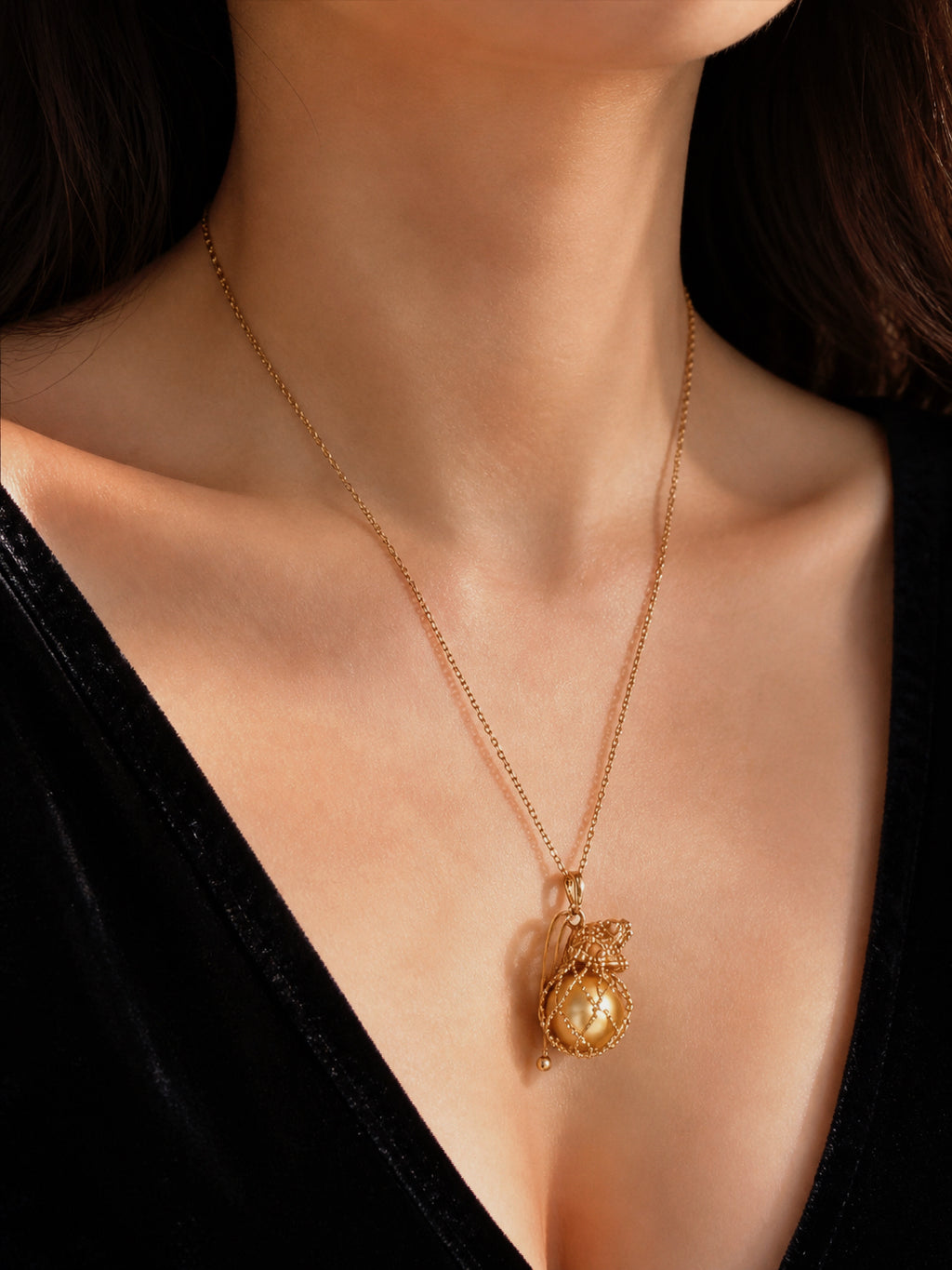 Gold net pouch pendant with pearl, worn on thin chain necklace