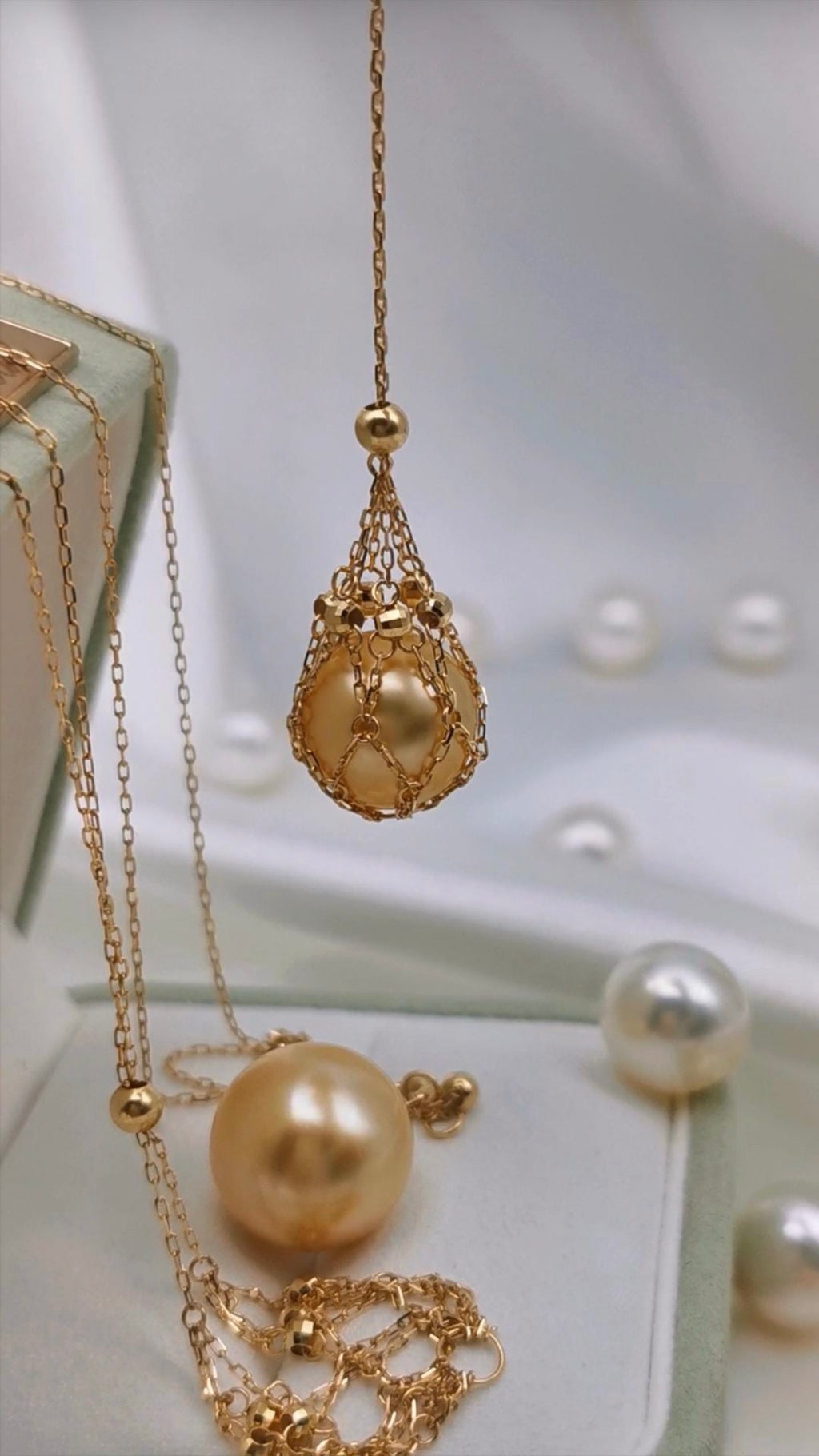 Gold tone pendant necklace on set with teardrop net charm and pearl bead accents