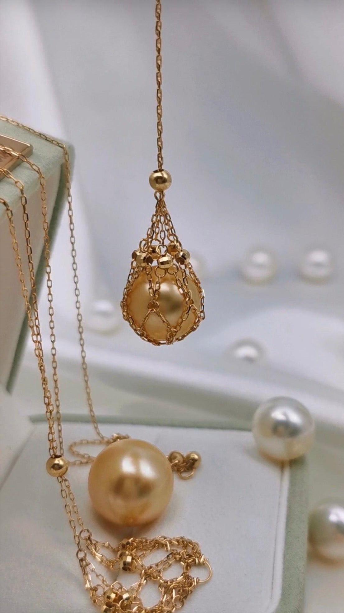 Gold tone pendant necklace on set with teardrop net charm and pearl bead accents