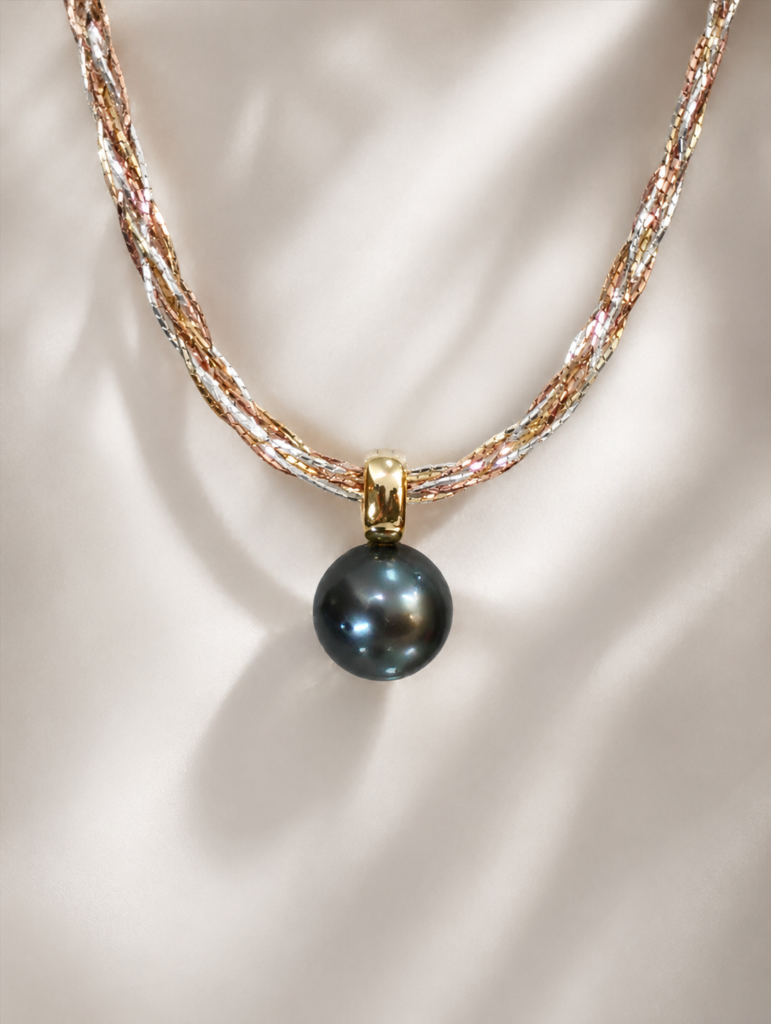 Three-tone braided gold necklace with dark pearl drop