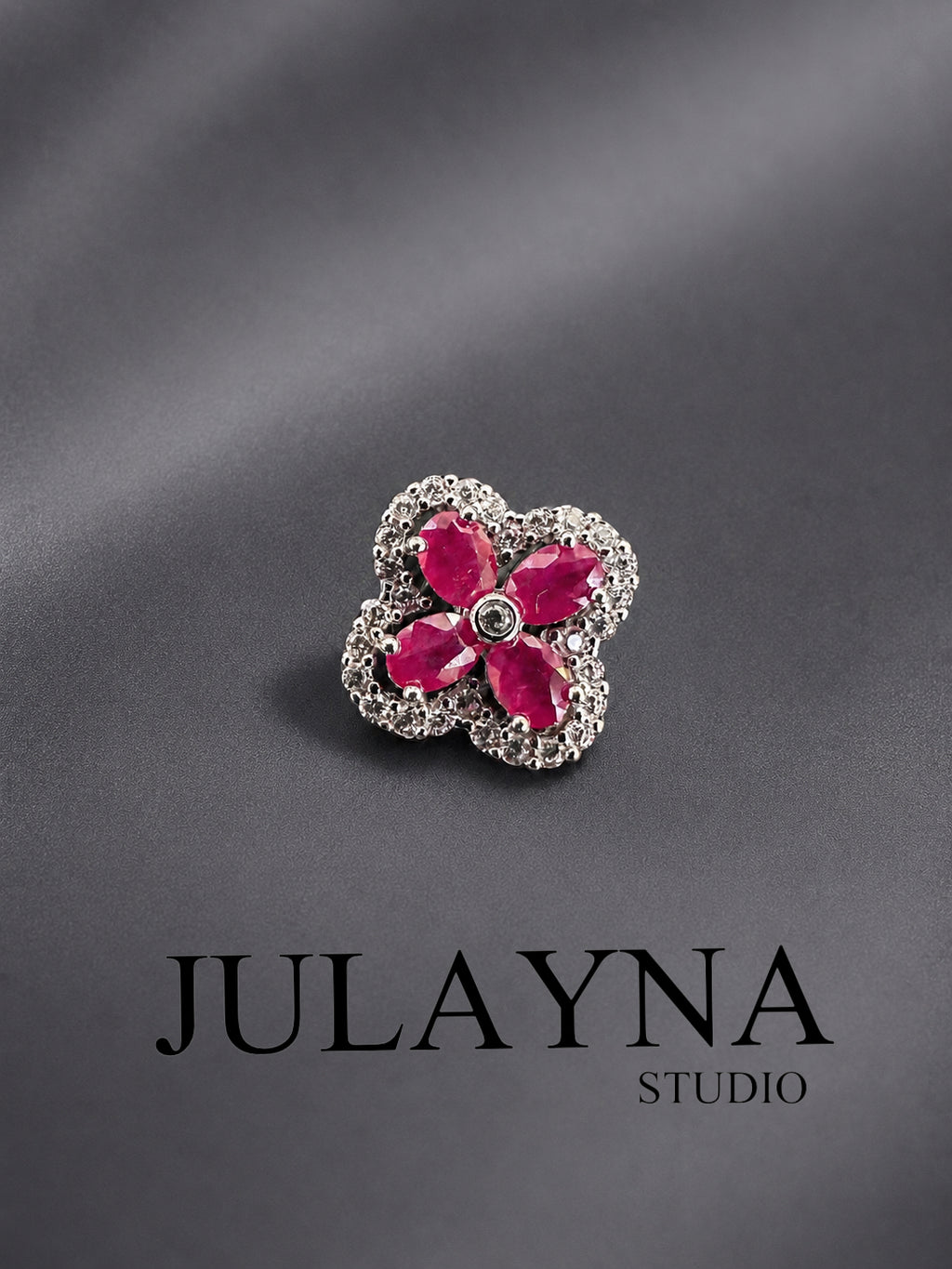 Sterling silver ruby clover pendant with four round pink-red gemstones in a halo setting