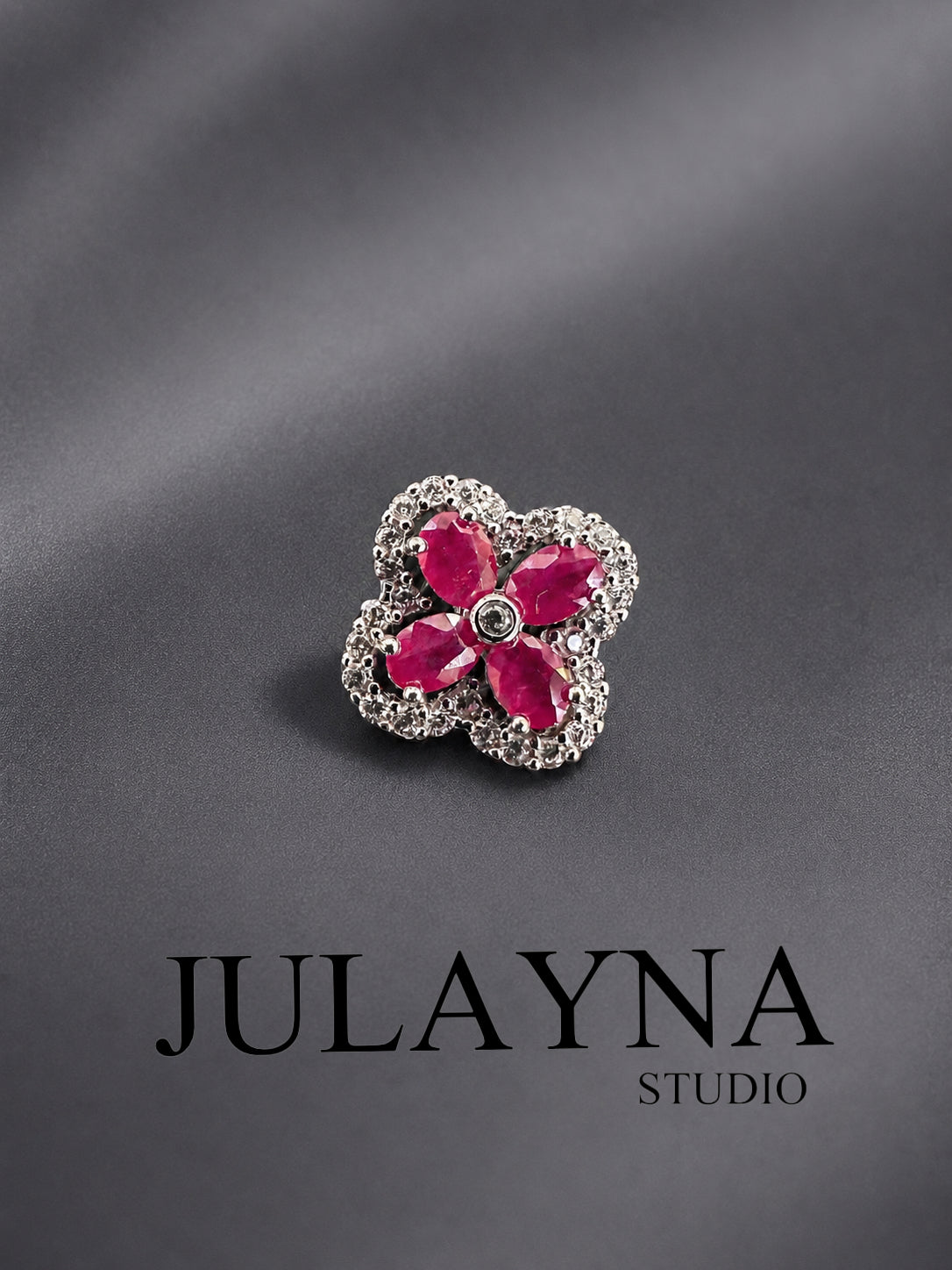 Sterling silver ruby clover pendant with four round pink-red gemstones in a halo setting