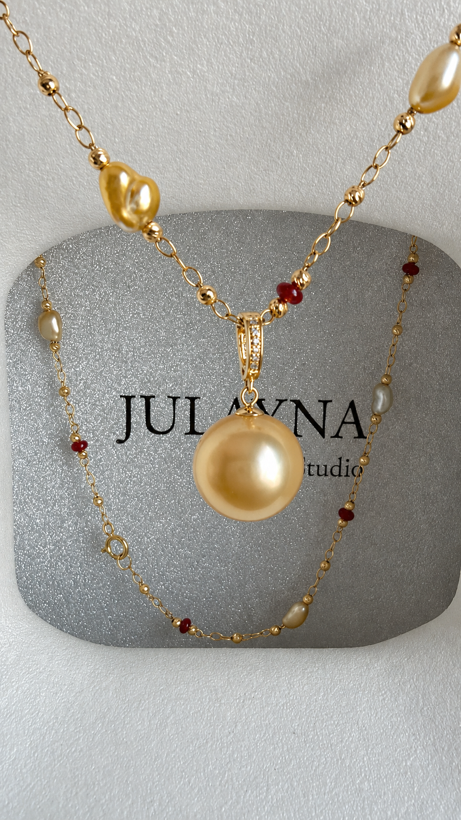 Gold pearl pendant necklace with red bead details and small gold links