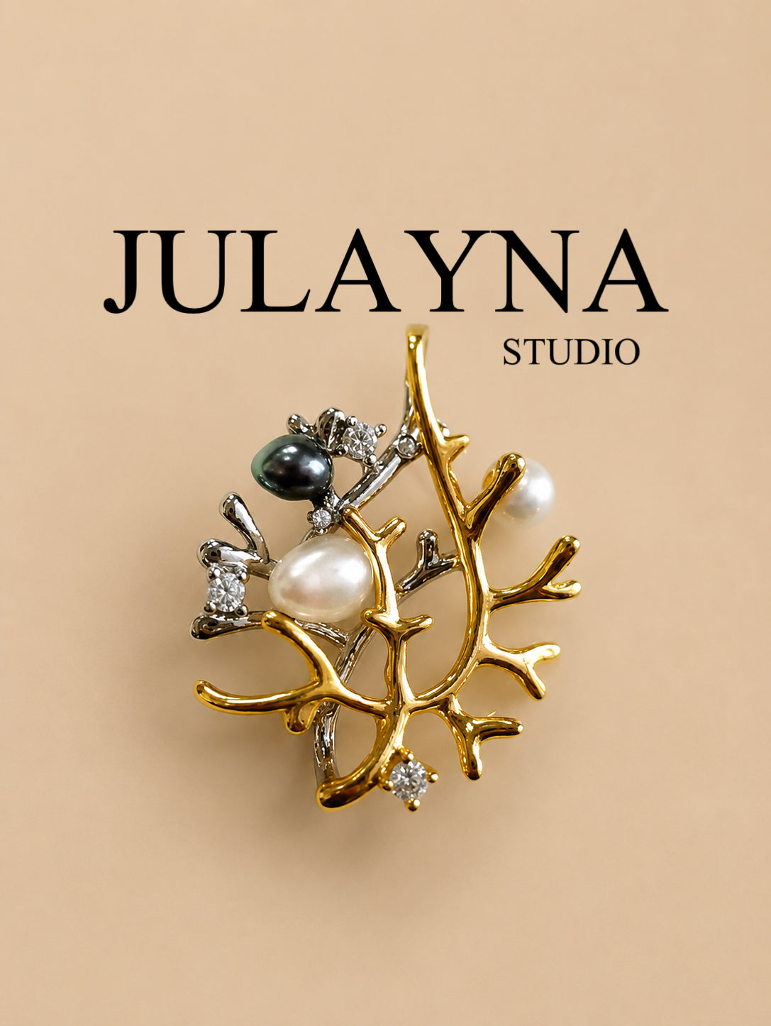 Pendant charm with pearl, dark bead, and rhinestone details on a gold-tone branch setting
