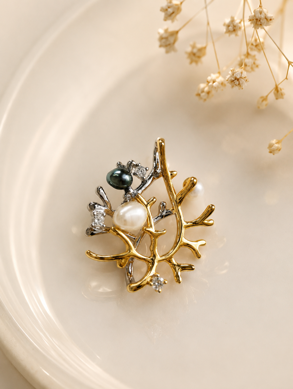 Branch-style pendant charm with pearl, dark bead, and rhinestone accents on gold-tone settings