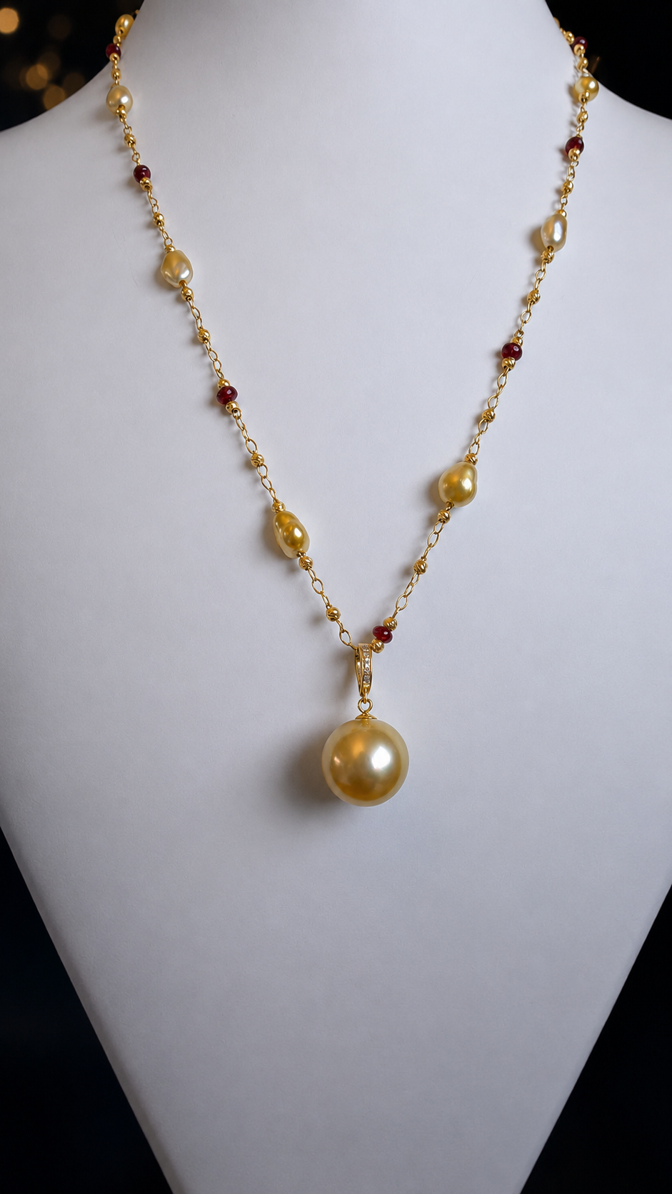 Gold pearl pendant necklace with small red gemstone bead accents