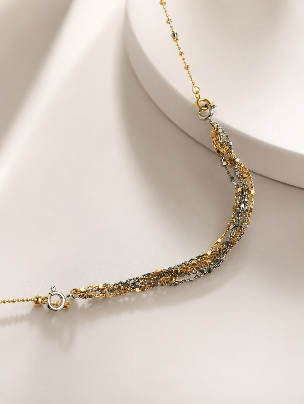 Gold and silver bead extender chain with circular clasp links and curved drape