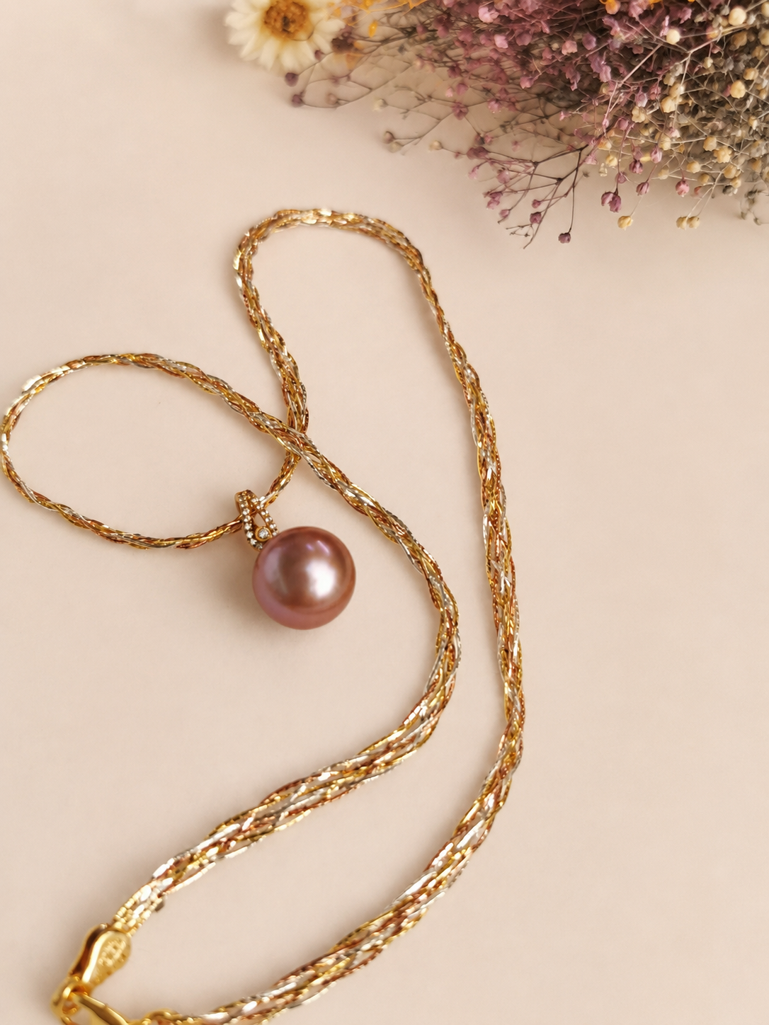 Gold layered necklace with purple pearl pendant drop and small diamond accents