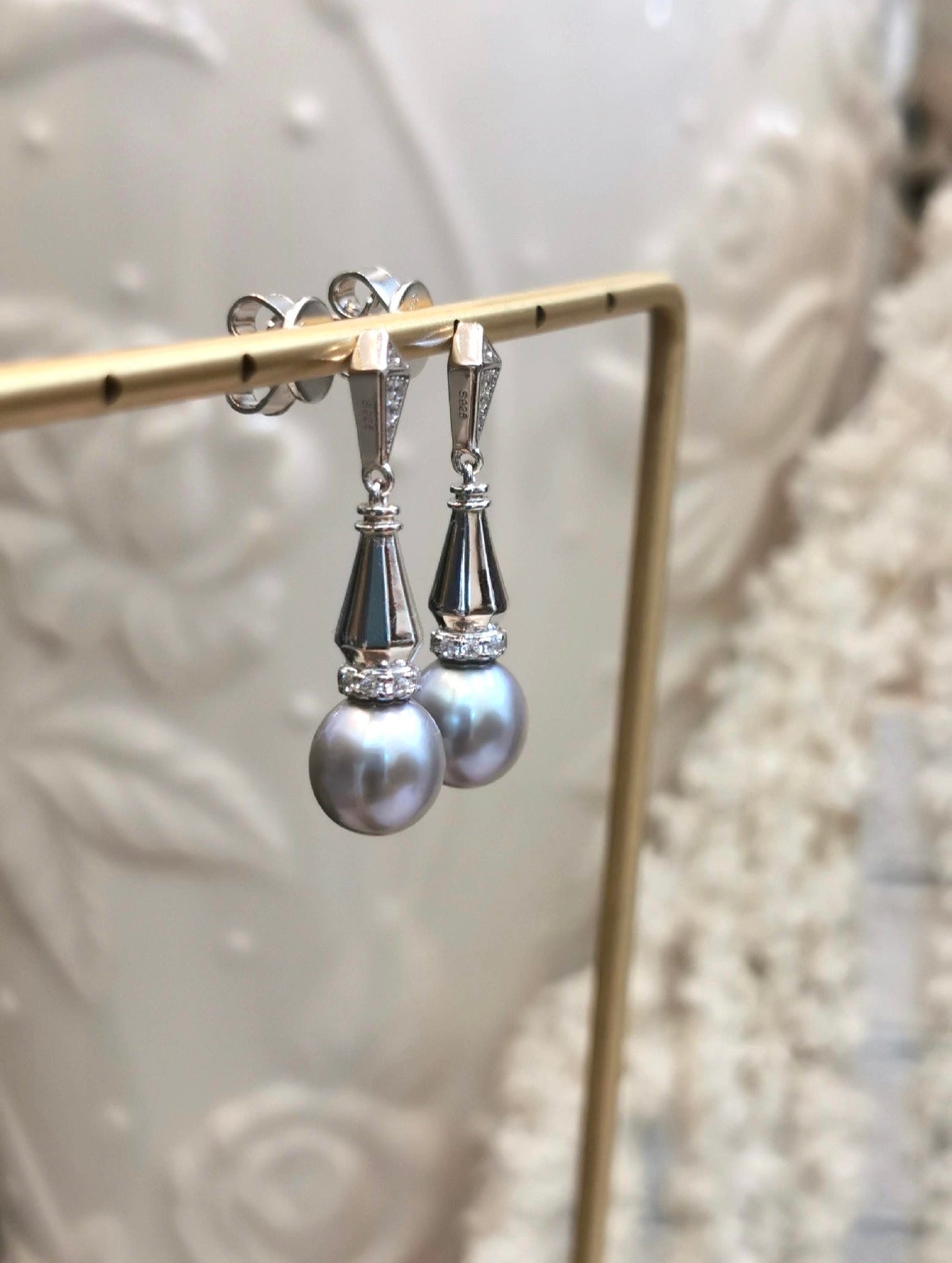 Silver-tone dangle earrings with gray teardrop pearls and sparkling geometric drops