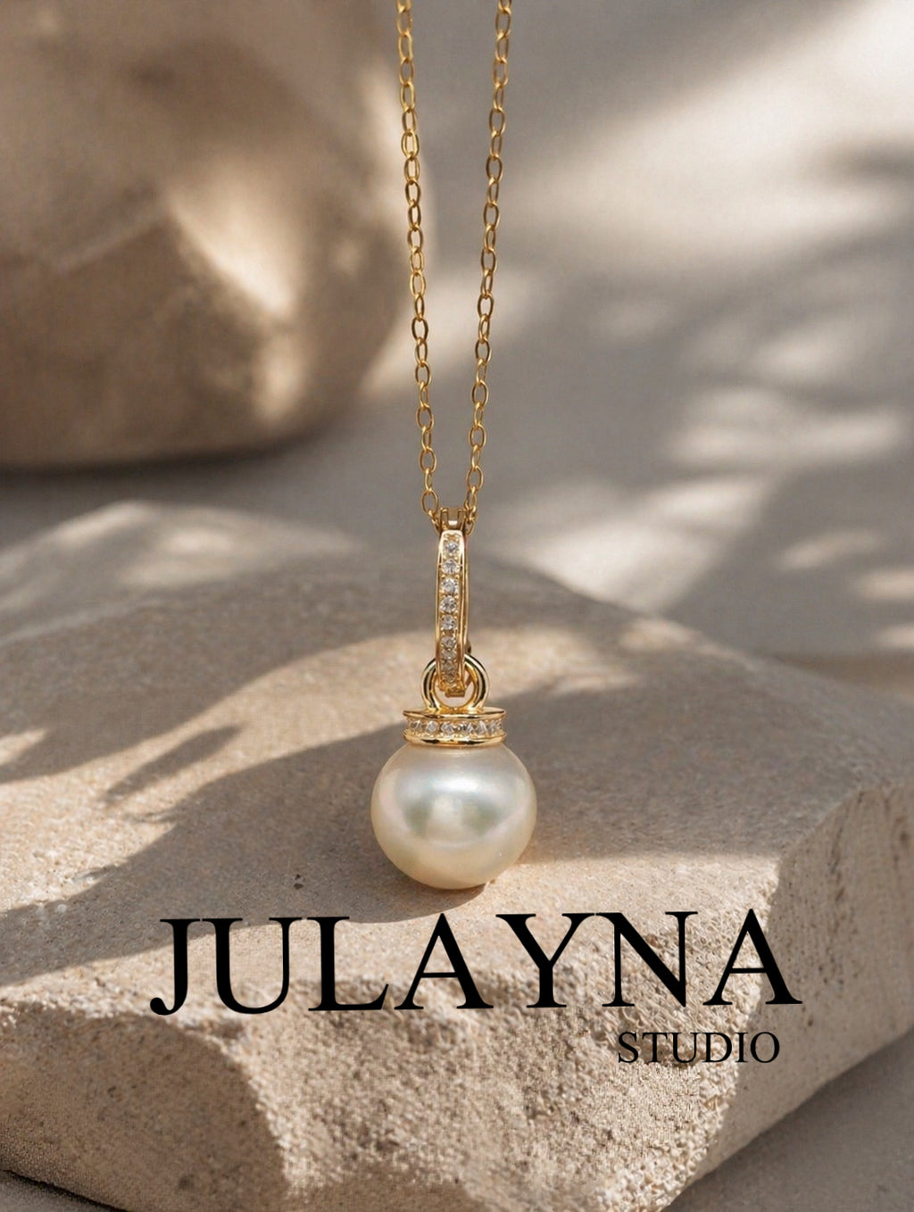 Gold pearl pendant with gemstone-set bail on a fine chain