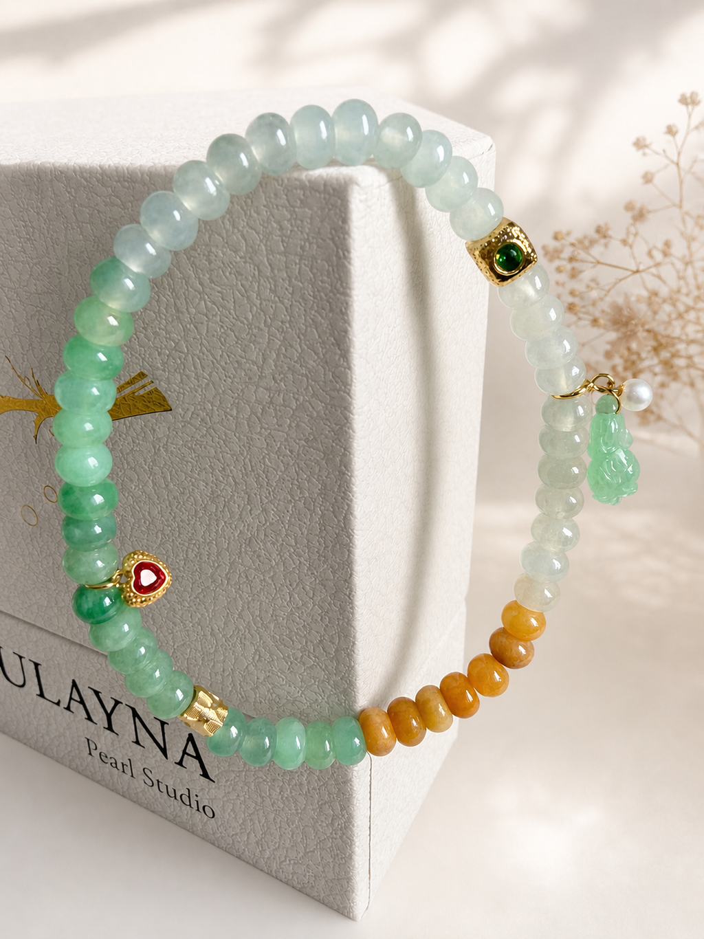 Jadeite beaded bracelet with mint and white beads, gold charms, and orange accent beads