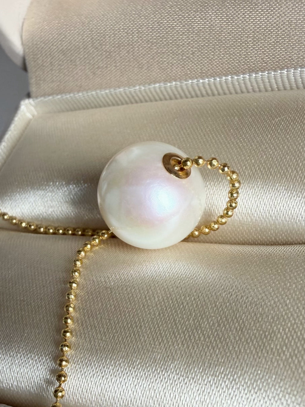 Round white freshwater pearl pendant with gold-tone chain detail