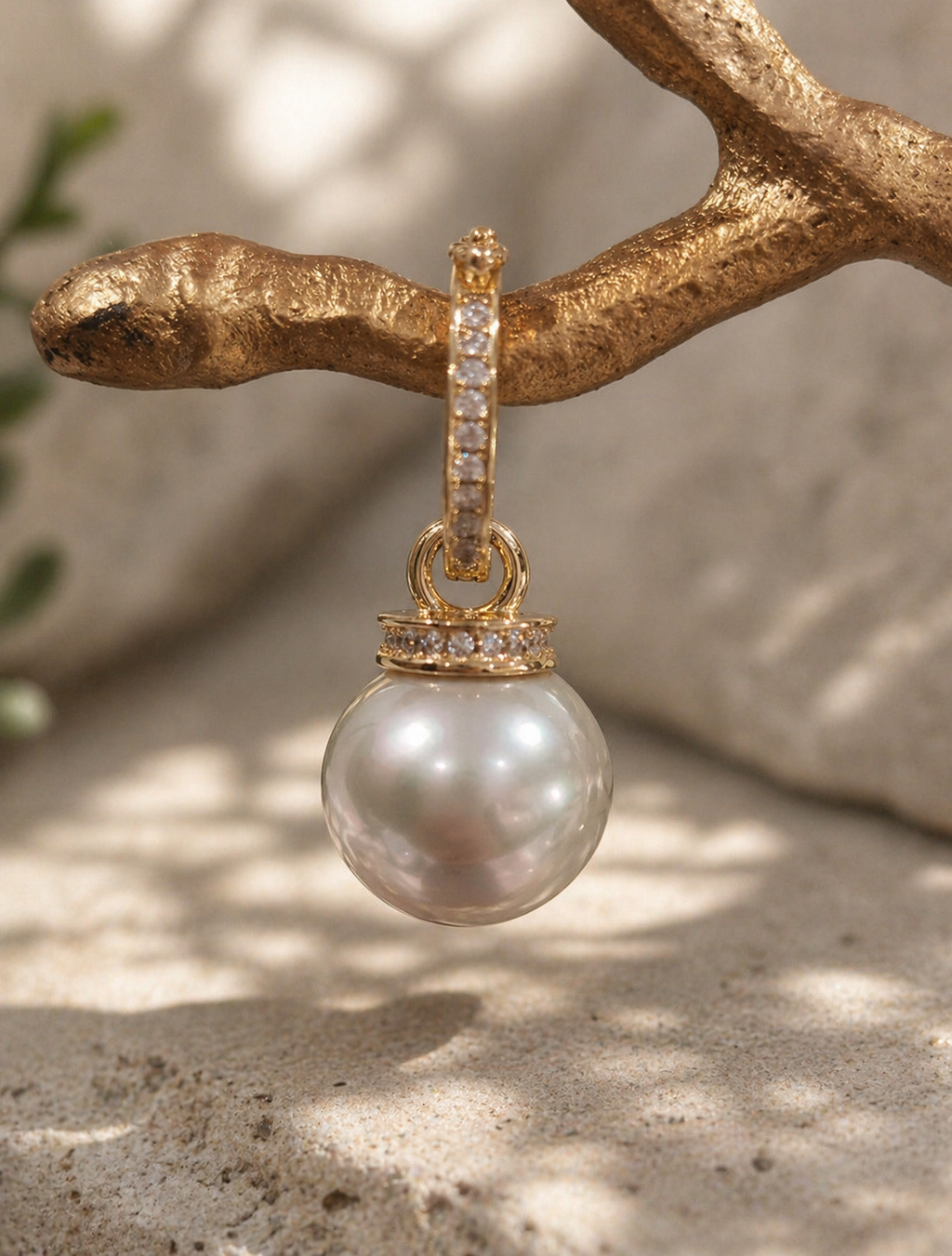 Gold pendant necklace featuring a round South Sea pearl and pavé bail