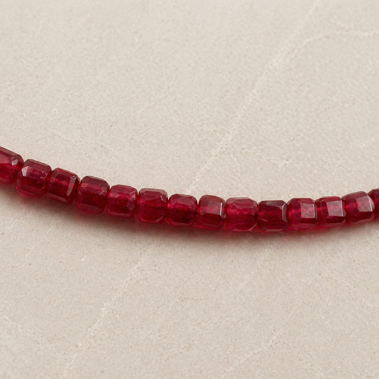 Close-up of ruby square-cut bead strand necklace with faceted beads