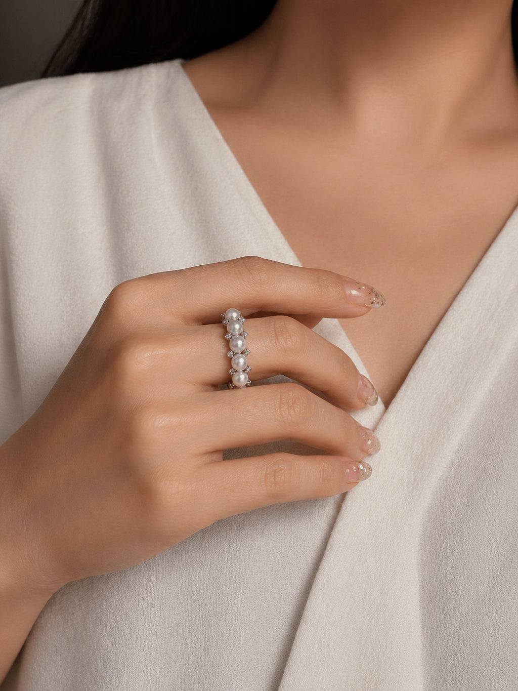 Adjustable silver pearl ring with five white freshwater pearls worn on hand
