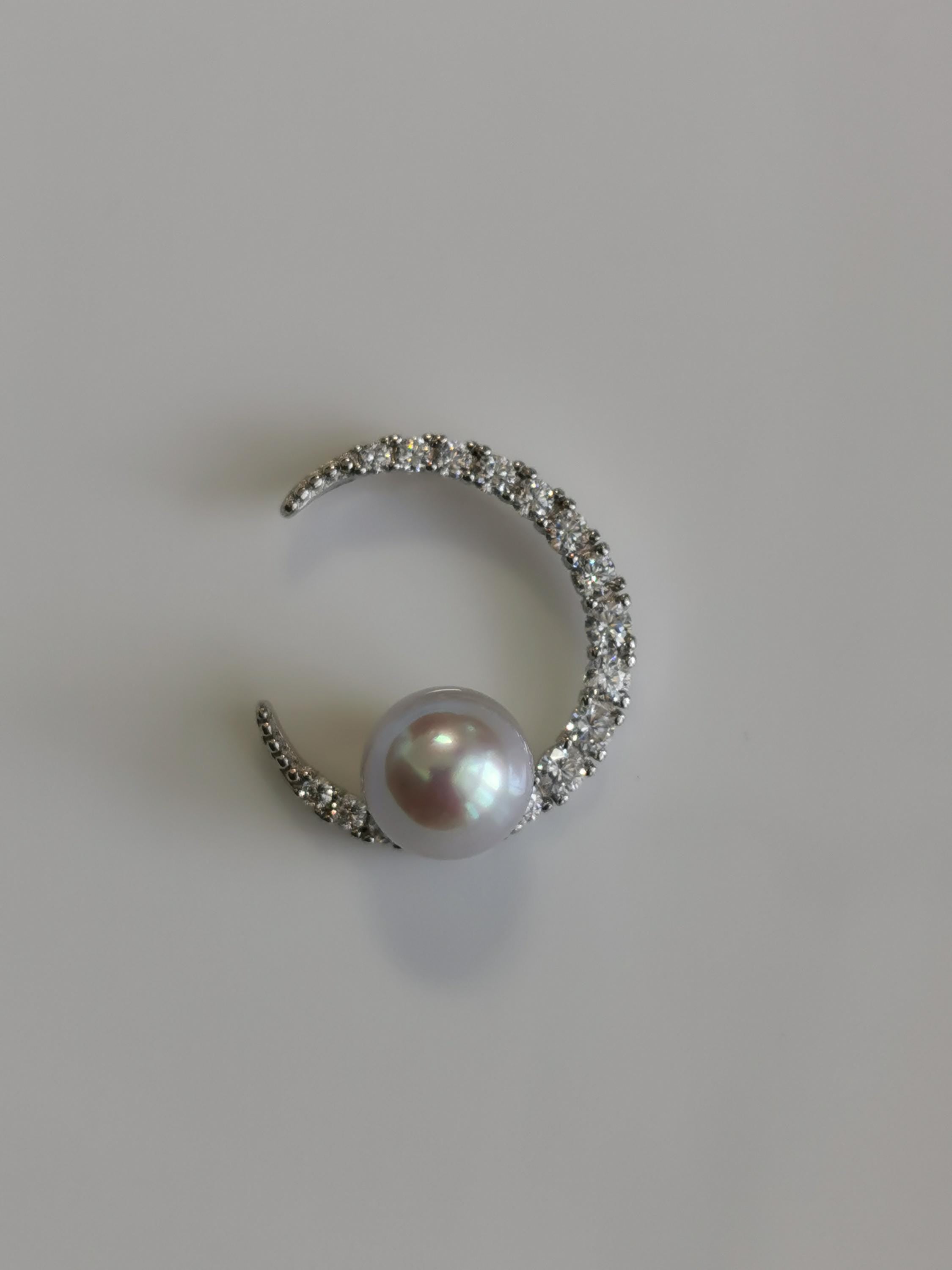 Silver crescent pendant with round pearl and glittering pavé stone surround