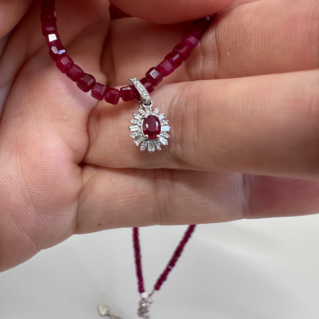 Ruby bead necklace with silver-toned ring and red gemstone flower charm