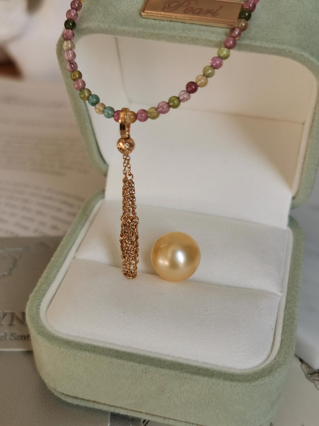 Gold pearl and teardrop net pendant on multicolor bead necklace