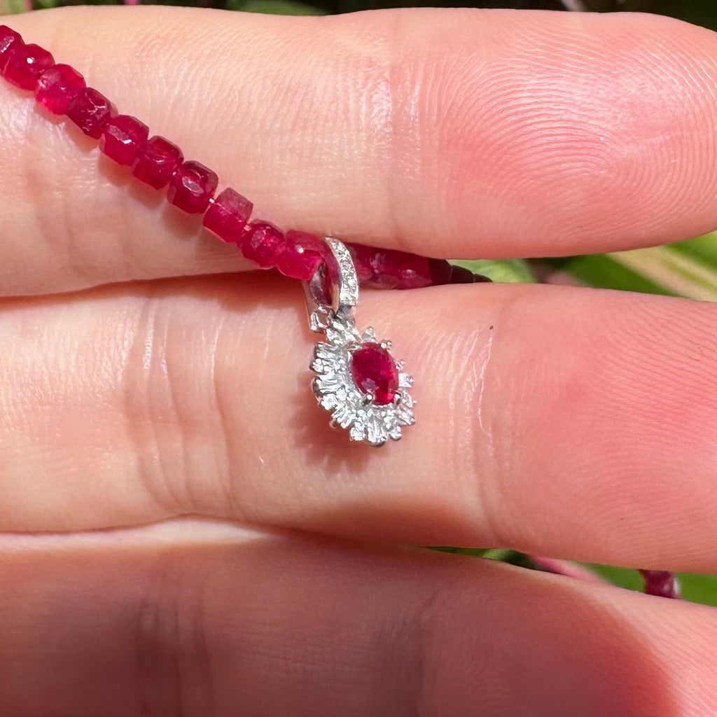 Ruby bead necklace with silver-toned connector and red gemstone flower charm